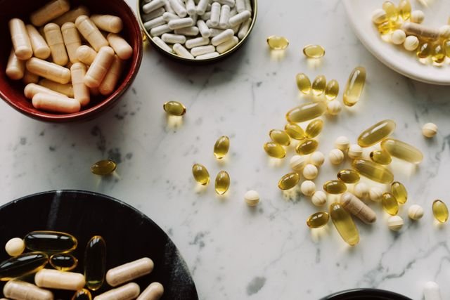 Assorted capsules and dietary supplements on a marble surface