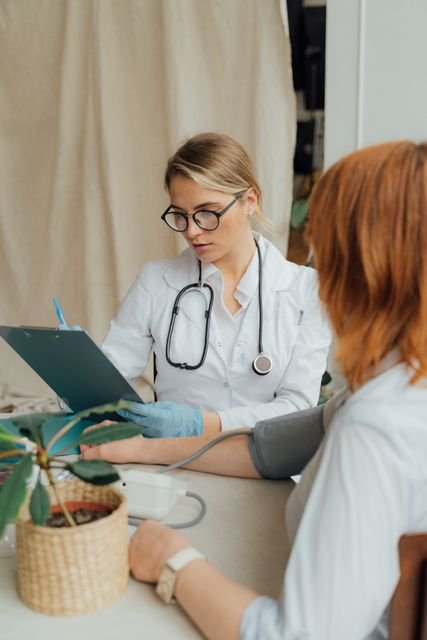Doctor checking a patient's blood pressure during a consultation