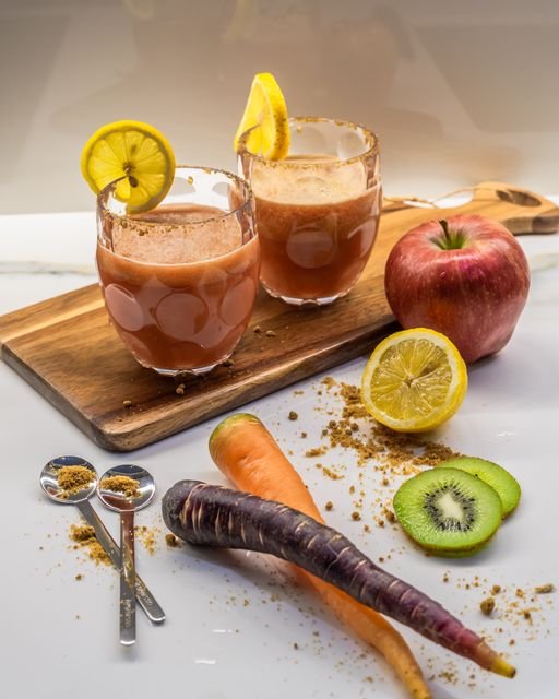 Two vegetable and fruit smoothies with carrots apple lemon and kiwi