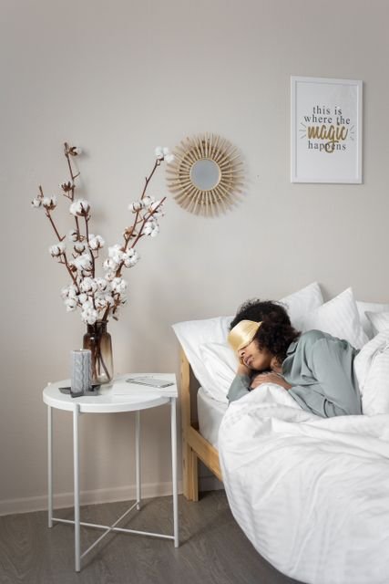 Woman sleeping in bed while wearing a sleep mask