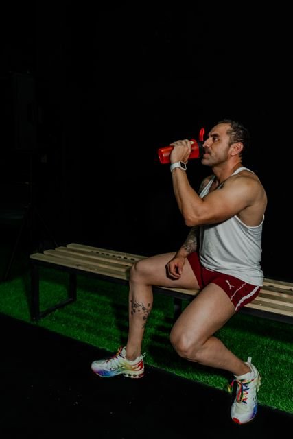 How Much Pre-Workout Should You Take? A Safer Guide to Serving Size, Caffeine, and Scoop Amount 6 Man resting in a gym while drinking from a shaker