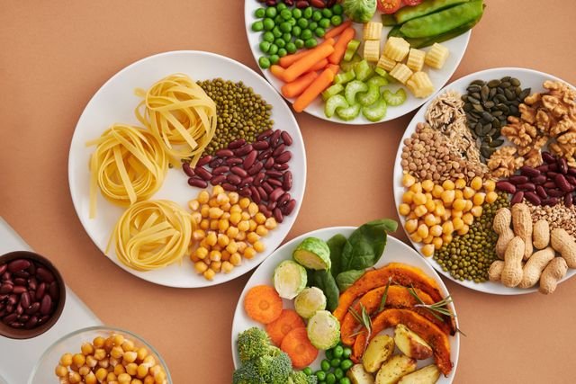 Assorted vegetables, legumes, nuts, seeds, and pasta on plates