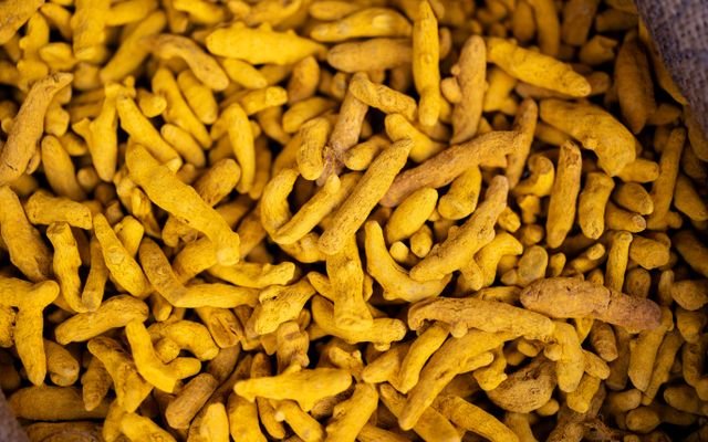Close-up of bright yellow turmeric roots in a market