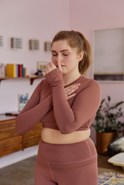 Woman practicing a breathing exercise indoors