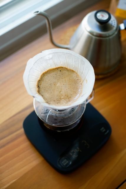 Matcha vs Coffee: Caffeine, Energy, Health Effects, Cost, and Which Fits You Better 4 Pour-over coffee brewing on a scale beside a kettle