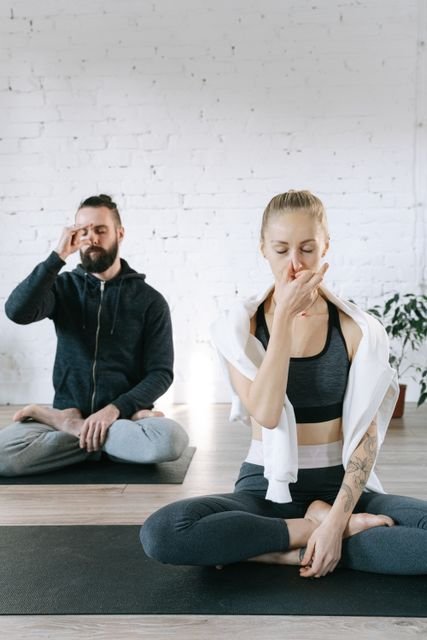 Two people seated indoors practicing controlled breathing